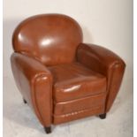 A contemporary Art Deco style brown tan leather armchair. Of French club armchair style having