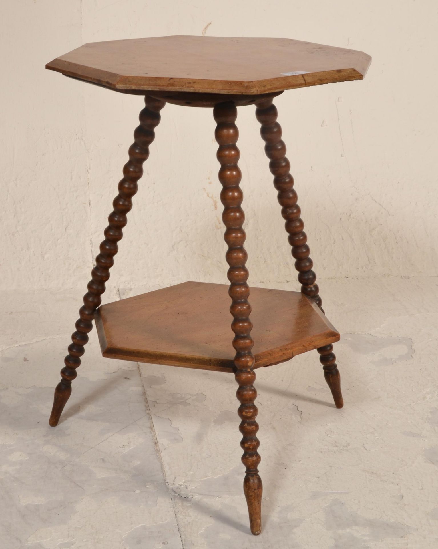 A Victorian 19th century walnut lamp table being raised on bobbin turned legs in the manner of