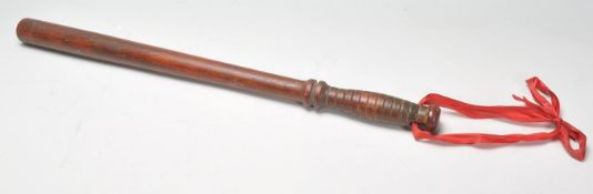 An early 20th Century 1930's police wooden truncheon having a turned carved handle.