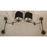A pair of retro 20th century brass adjustable wall lights. Each with roundel metal wall mounts,
