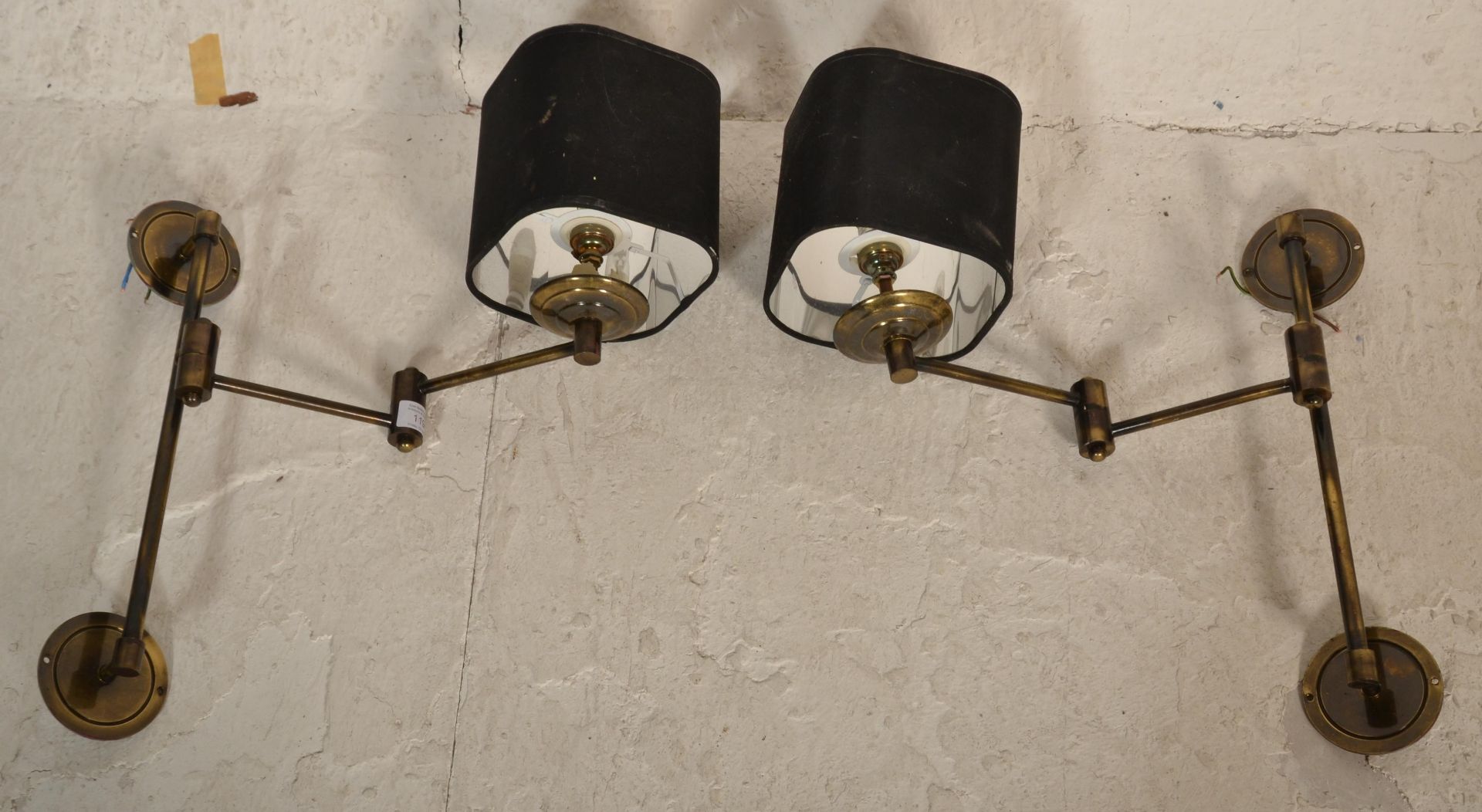 A pair of retro 20th century brass adjustable wall lights. Each with roundel metal wall mounts,