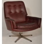 A vintage retro 20th Century button back swivel armchair, upholstered in an oxblood leatherette