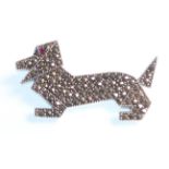 A stamped sterling silver brooch in the form of a Daschund of stylised angular form, being set