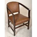 An early 20th Century armchair / desk chair having a bowed back rest with studded leather borders