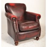 A 20th century Thomas Lloyd oxblood leather chesterfield armchair having bun feet with barrel arms
