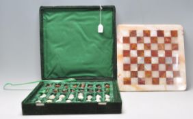 A vintage 20th Century marble and onyx chess set contained within a green velvet case. King measures