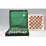 A vintage 20th Century marble and onyx chess set contained within a green velvet case. King measures