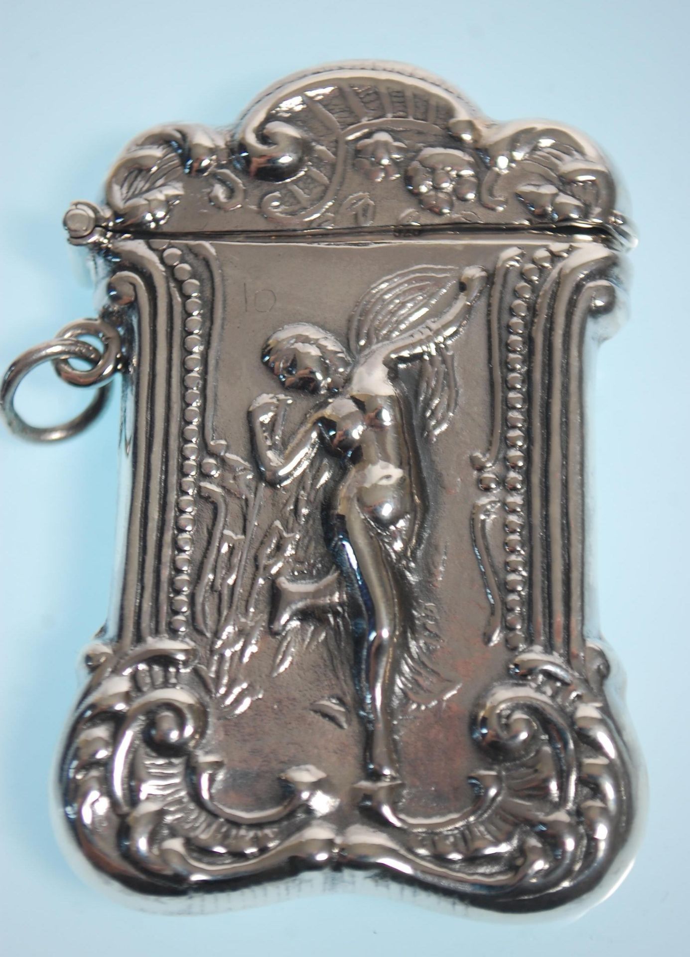 A stamped 925 silver vesta case having a repousse decoration fairy with scrolled borders. Measures