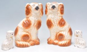 A pair of large 19th century Staffordshire spaniels in the manner of Beswick together with another