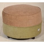A retro mid century circular barrel foot stool pouffe in a two tone upholstered colourway of beige