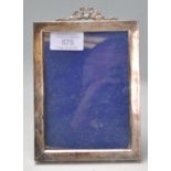An early 20th Century silver hallmarked easel back photo frame of rectangular form with ribbon