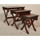 Theseira - A reproduction mahogany nest of graduating tables having carved frieze with flared tops