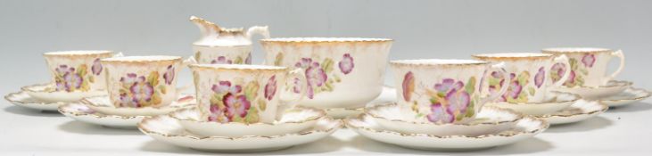 A 19th Century Victorian tea service decorated with painted purple flowers to the sides with gilt