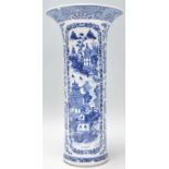 An early 20th Century Chinese blue and white vase of cylindrical form with a flared rim atop.