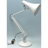A vintage retro 20th Century anglepoise desk lamp in the manor of Herbert Terry raised on a white