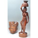 To carved wooden Balinese figures to include a wall hanging mask in the form of a man in a