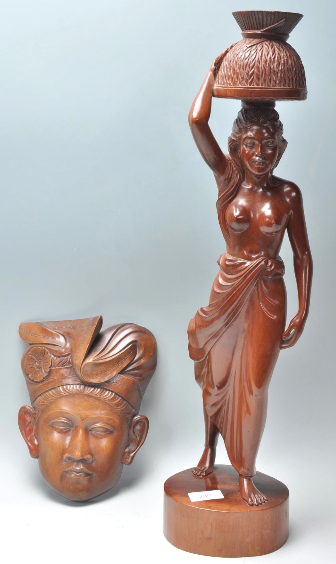 To carved wooden Balinese figures to include a wall hanging mask in the form of a man in a