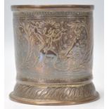 A vintage 20th Century Indian brass brush pot of cylindrical form with finely engraved dancing