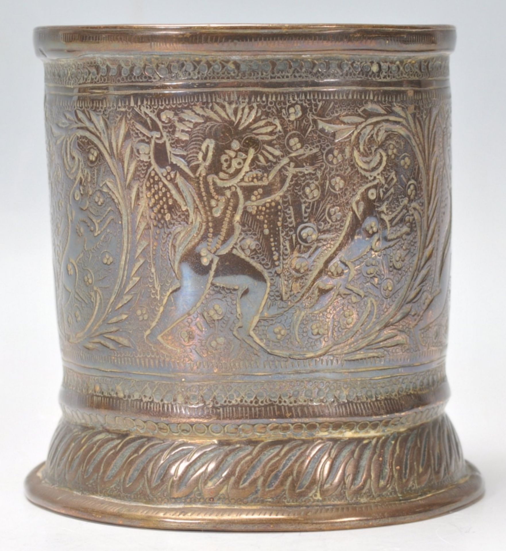 A vintage 20th Century Indian brass brush pot of cylindrical form with finely engraved dancing