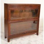 An early 20th century oak two tier sectional lawyers stacking bookcase cabinet with twin sections