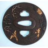 A 20th Century Japanese bronze tsuba of round form having raised bird and branch decoration with