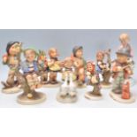 A collection of nine Goebel Hummel ceramic figurines to include apple tree boy, violinist, girl in a
