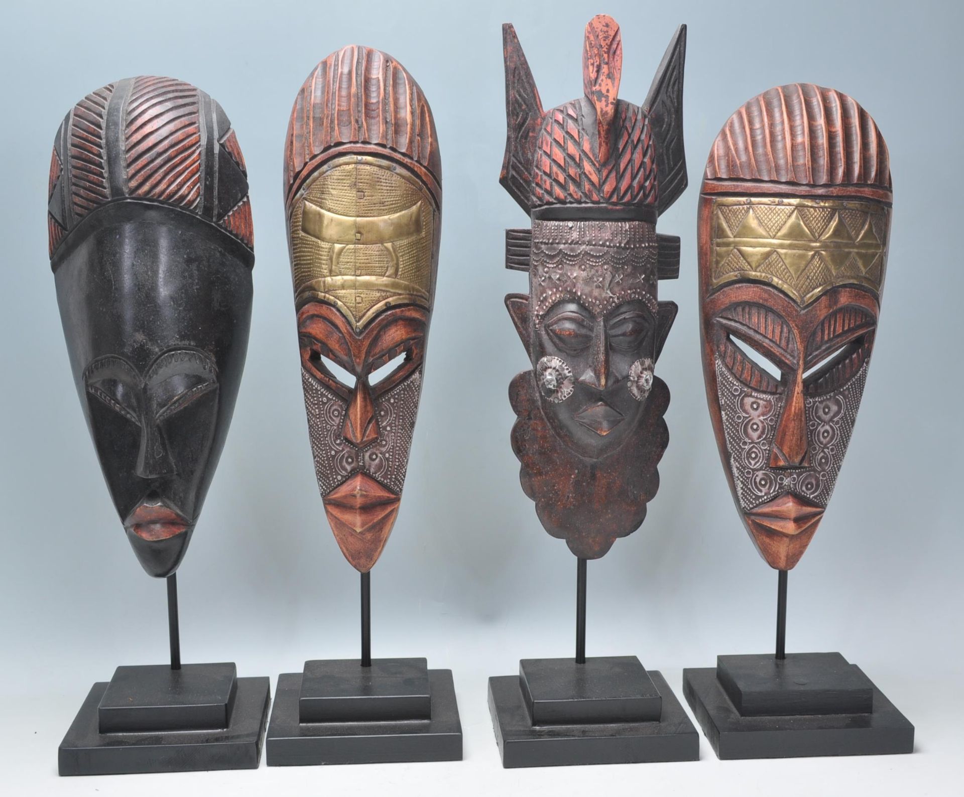 A group of four carved wooden African tribal masks each being raised on supports with stepped plinth - Bild 2 aus 8
