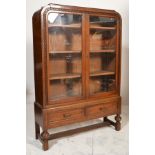 A 1930's Art Deco oak china display cabinet vitrine. Raised on cup and cover legs united by