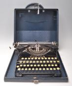 A vintage 20th Century cased Corona folding portable reporters typewriter having a lift up lid