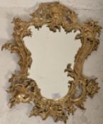 A late 19th / early 20th Century Rococo style gilt metal framed wall mirror. The frame with