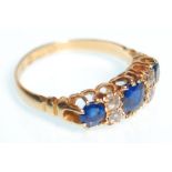 A hallmarked 18ct gold ring set with three round cut sapphires set alternately with four round cut