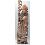 A 20th Century Chinese carved wooden figure in the form of the deity Shou Lau modelled with a