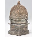 A good late 19th Century Eastern bronze buddha stand with embossed floral and elephant decoration to