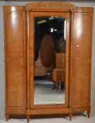 A good 19th century continental burr walnut triple armoire wardrobe having breakfront mirror door