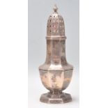 An early 20th Century silver hallmarked sugar caster shaker raised on stepped octagonal base with