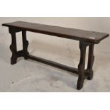 A 19th Century Victorian pine church bench having a plank top raised on two carved and shaped
