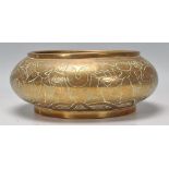 An early 20th Century bronze bowl of squat form engraved with dragons and floral decoration.