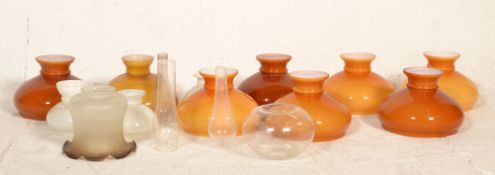 A collection of vintage 20th century glass oil lamp shades. To include amber and white glass