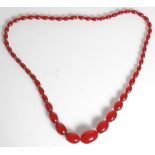 An early 20th Century necklace of graduating oval cherry bakelite beads. Measures 30 inches.