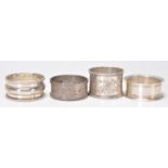 A group of four silver hallmarked napkin rings to include a napkin ring with gadrooned border (
