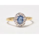 A hallmarked 18ct gold ladies dress ring set with a central blue sapphire with diamond accent stones