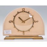 A 1930's Art Deco mantel clock having half moon glass face with peach backing, baton numerals with
