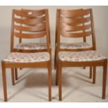 A set of 4 Danish teak wood dining chairs having tapering legs with pad feet and overstuffed pad