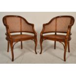 A pair of contemporary Antique style walnut smokers bow armchairs having bergere caned seat pads and