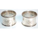 Two silver hallmarked napkin rings to include one with gadrooned borders and engraved initials to