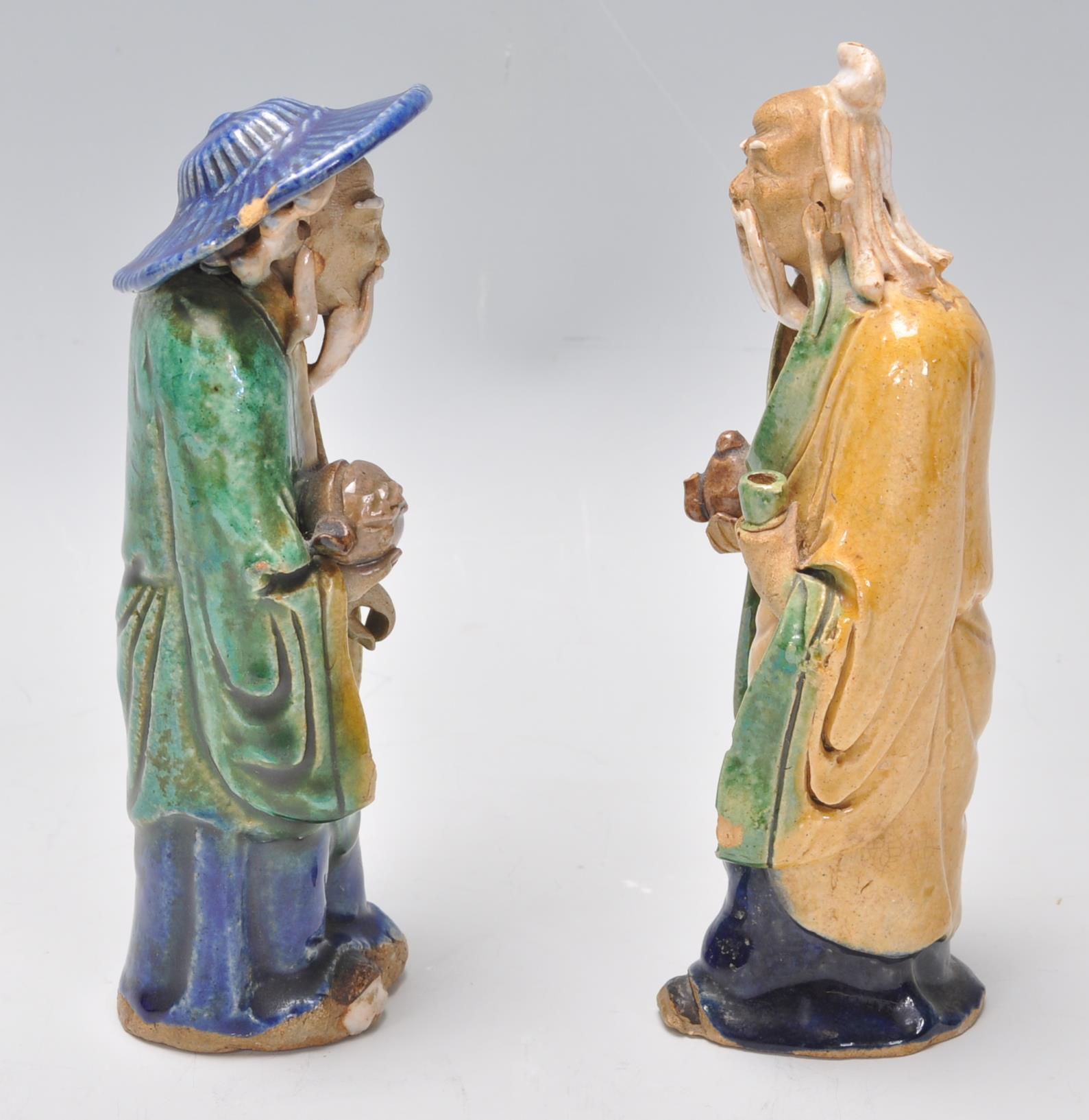 A pair of 1920's Chinese export Ming Dynasty style ceramic figurines in the form of two men glazed - Image 2 of 7