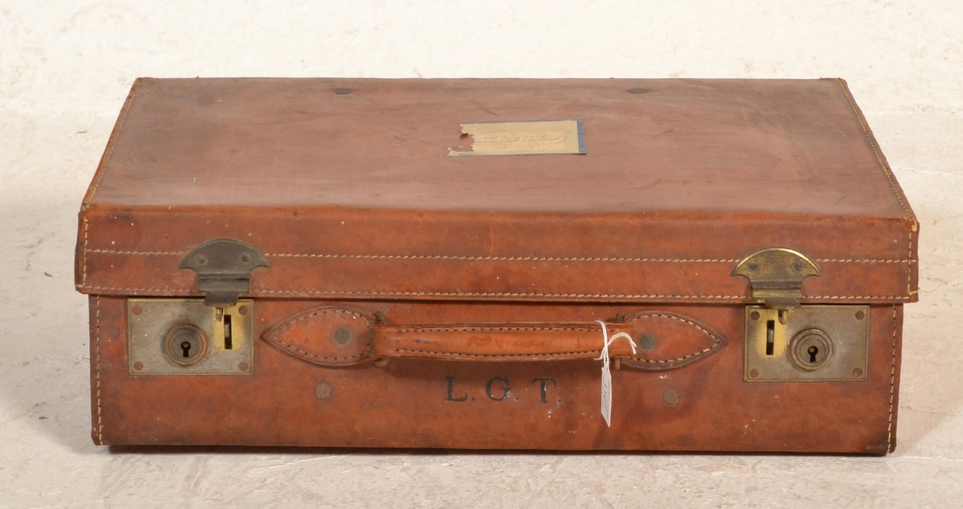 A good quality early 20th century leather suitcase with clasp locks and leather handles, remains - Image 2 of 4