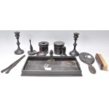 An early 20th Century ebonised wooden dressing table set consisting of mirror, tray, candlesticks,
