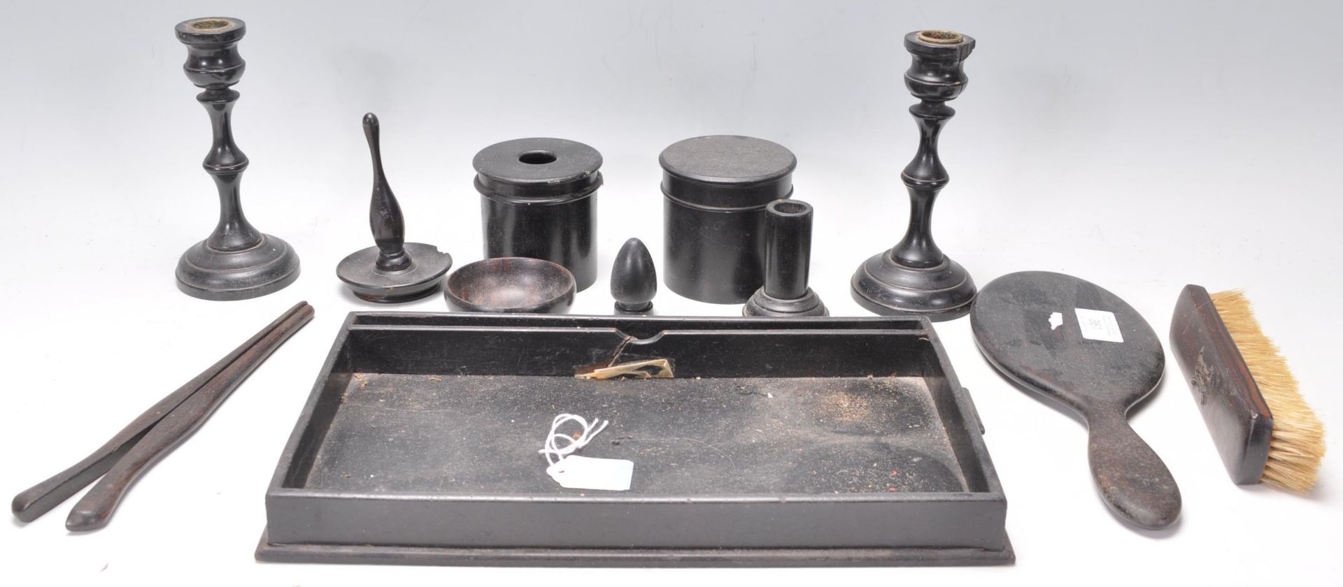 An early 20th Century ebonised wooden dressing table set consisting of mirror, tray, candlesticks,