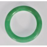 A Chinese green jade bangle of typical round form.